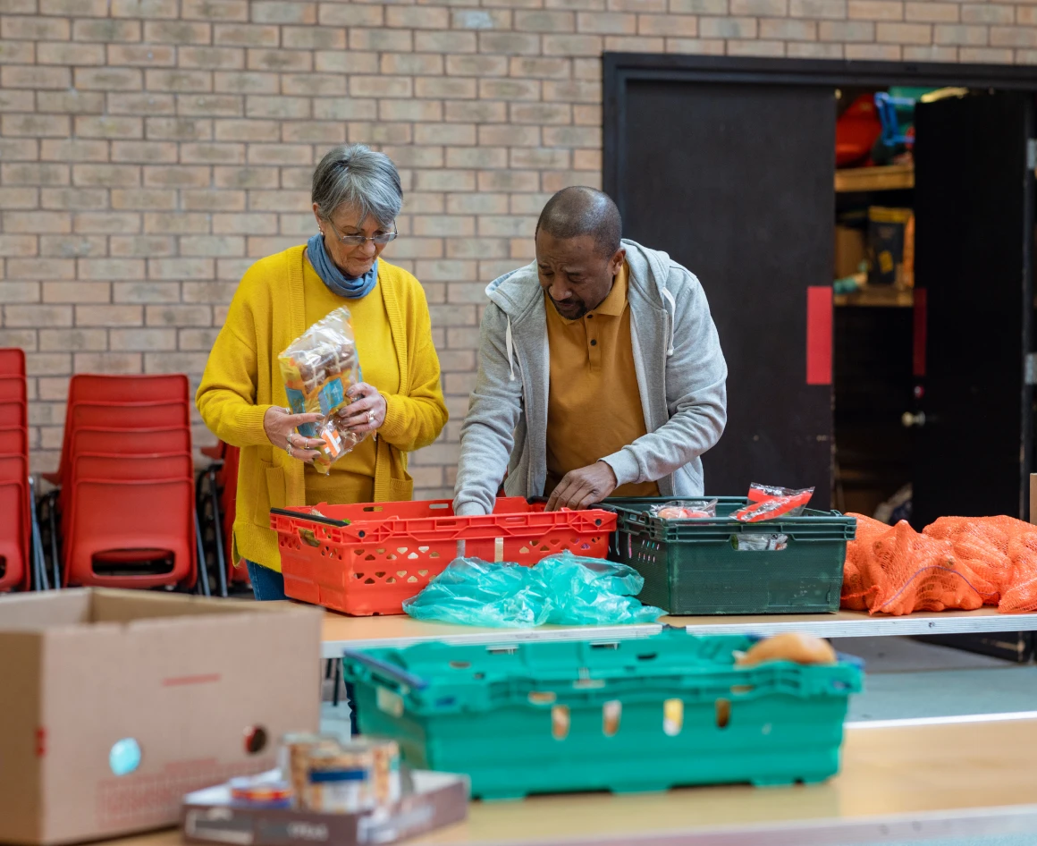 Volunteers sorting food donations at table.