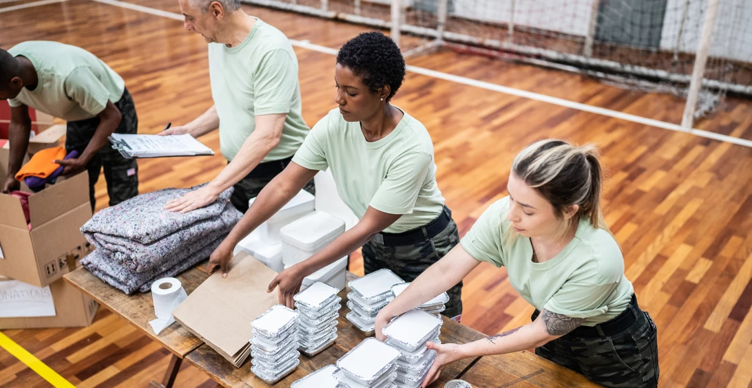 Volunteers packing supplies in a gymnasium.